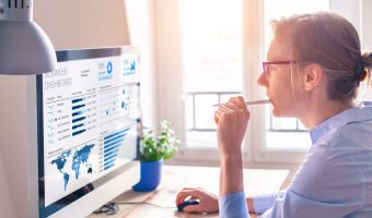 Businesswoman looking at business analytics (BA) or intelligence (BI) dashboard on the computer screen with sales data statistical report and key performance indicators (KPI)